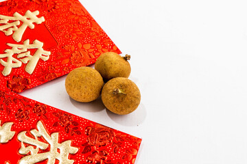 close up longan fruit with hongpao or red envelope chinese new year isolated in white bacground
