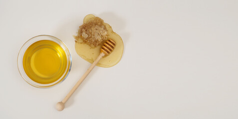 Banner with natural delicious fresh honey, honey wooden spoon, honeycomb on a white background with space for text, top view, flat lay. Healthy food concept
