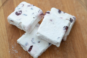 Sweets, marshmallows, lying on a wooden board, on the windowsill. Surprise, holiday of sweets, sugar addiction, handmade, the right sweets