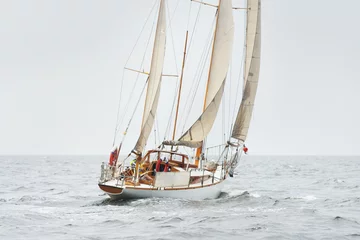 Wandaufkleber Old expensive vintage two-masted sailboat (yawl) close-up, sailing in an open sea during the storm. Sport, cruise, tourism, recreation, transportation, nautical vessel. Panoramic view, seascape © Aastels