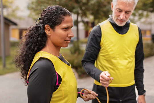 Visually impaired woman preparing for jogging with guide runner