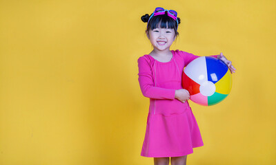 Portrait of little cute asian girl wearing swimsuit goggles isolated on yellow background with copy space. Education childhood healthy lifestyle vacation holiday, summer holiday concept.