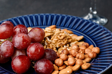 Close up of nuts and grapes on plate
