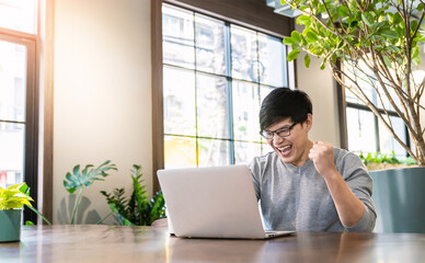Portrait of smiling handsomel startup business asian man working in office desk using computer....