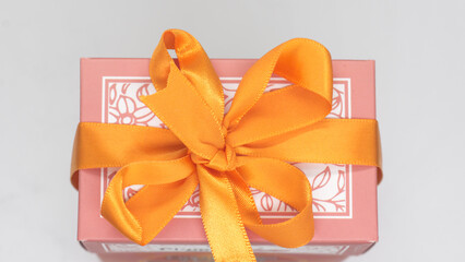 Pink gift box with orange bow for a fun holiday or birthday party