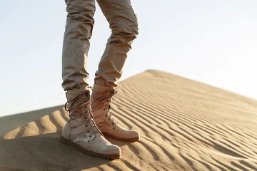 A tourist stands in the desert in beige pants and boots © yaslex