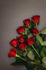 Naklejka na ściany i meble Bouquet of fresh burgundy roses on a black stone concrete background