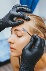 Fototapeta premium Young woman with make up brush near her face. Closeup