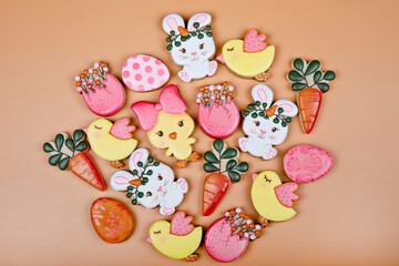 Closeup of variation of different Easter sugar cookies decorated with royal icing. Eggs, bunny, carrots and chicken on yellow background. Lovely sweet gift or postcard