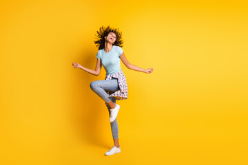 Fototapeta na wymiar Full length photo of carefree charming dark skin curly woman dressed blue t-shirt dancing isolated yellow color background