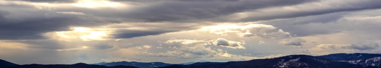Obraz premium The Sun behind the clouds in winter in the mountains