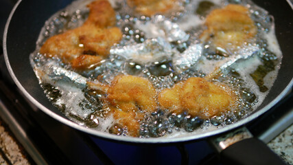 Chicken cutlets frying in a pan