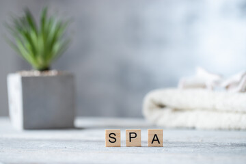 Spa wooden word on the background of green flower and a towel