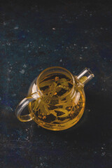 Linden tea in a modern teapot on a dark background. Minimalism and healthy organic products