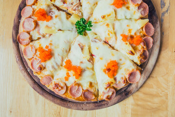 Hawaiian Pizza on wooden plate  