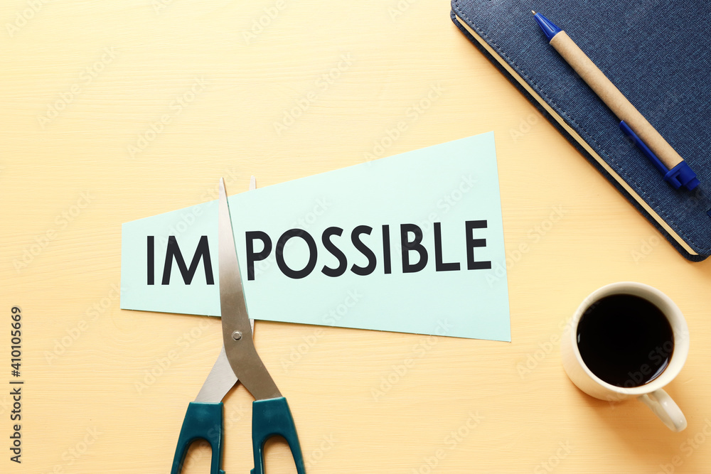 Poster man hand holding card with the text impossible, cutting the word im so it written possible. success 