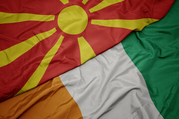 waving colorful flag of cote divoire and national flag of macedonia.