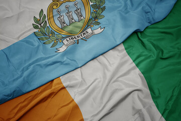 waving colorful flag of cote divoire and national flag of san marino.