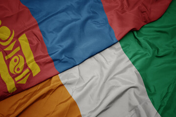 waving colorful flag of cote divoire and national flag of mongolia.