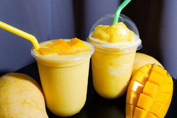 Mango smoothie in the glass with fresh mango 