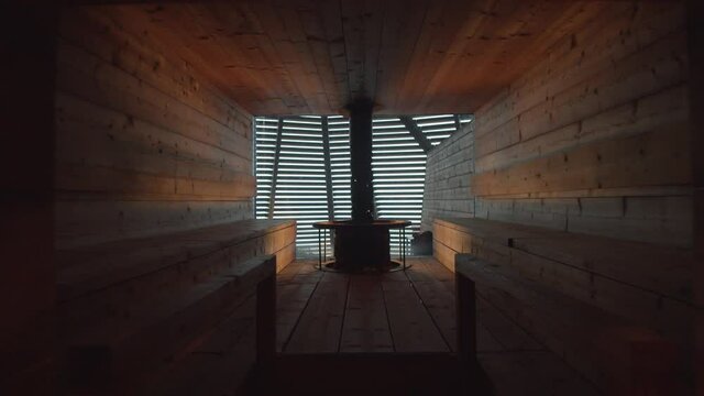 Slow tracking in shot of Finnish sauna interior with lights on