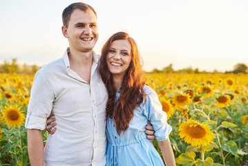 Smiling happy newlywed couple in a field of sunflowers. The concept of love, mutual respect and right relationships