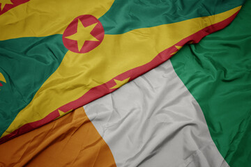 Obraz premium waving colorful flag of cote divoire and national flag of grenada.