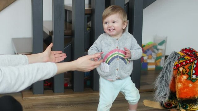 Baby making first steps. Kid learning how to walk