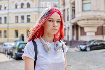 Fashionable teen girl with bright dyed colored hairstyle on city