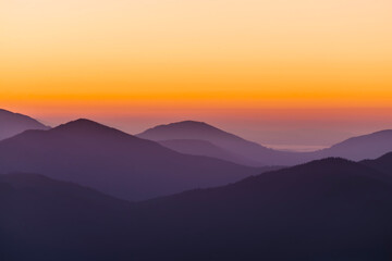 Fototapeta na wymiar Silhouette of mountain ranges in the haze at dawn.