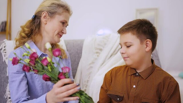 Boy gives flowers to grandmother