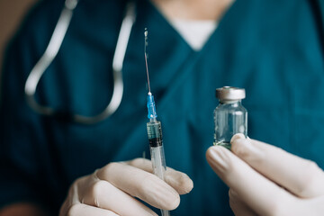 The doctor holds a syringe and a vaccine in his hand. Vaccination against covid-19. Coronavirus. Flu vaccination.