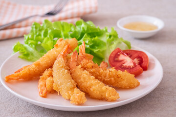 Fried breaded shrimp with vegetable on plate and plum sauce..