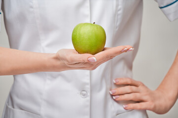 nutritionist doctor healthy lifestyle concept - holding organic fresh green apple