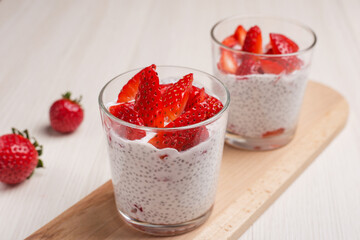 Chia seed pudding with fresh strawberry in glass ready to eat. Healthy breakfast. Vegan food. Superfoods concept with copy space.