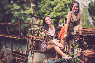 Female Friends On Abandoned Vehicle At Field
