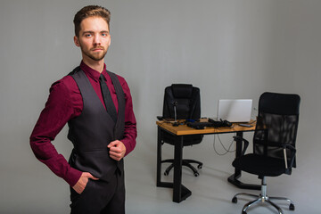a young handsome man with a beard in a bright room is standing at a table, on the table are sensors...