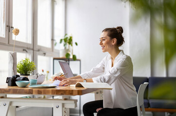 Creative young woman working on laptop in her studio
