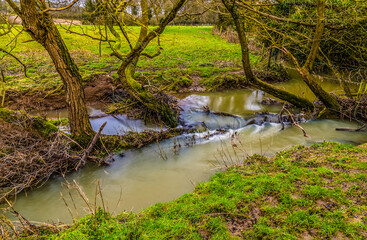 A long exposure view of a small weir on the River Welland in winter near Lubenham, UK