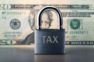 Close up of lock with TAX text on money background. Locked tax concept.
