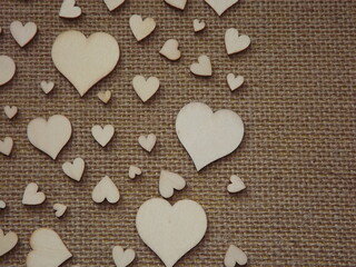 wooden hearts of different sizes on jute fabric as a Valentine's day greeting card. High quality photo