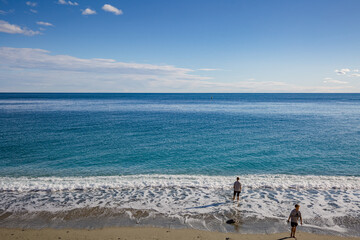 Monterosso al Mare, Italy - October, 2020: Serene seascape. The young guys go out walking along the seashore.