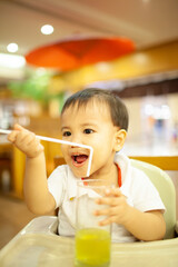 little boy playing the straw in the restaurant