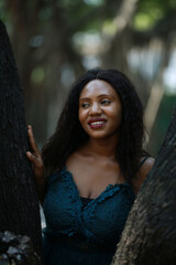 Naklejka premium Cheerful young woman standing by tree in the jungle.