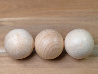 Drei Holzkugeln vor hölzernem Hintergrund