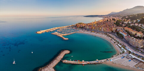  Sand beach beneath the colorful old town Menton on french Riviera, France. Drone aerial view over...