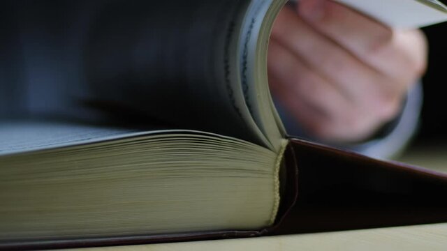 Male hand flipping through the pages of a book, closeup view
