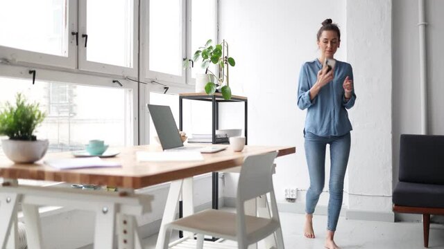 Young business woman using smartphone in loft office
