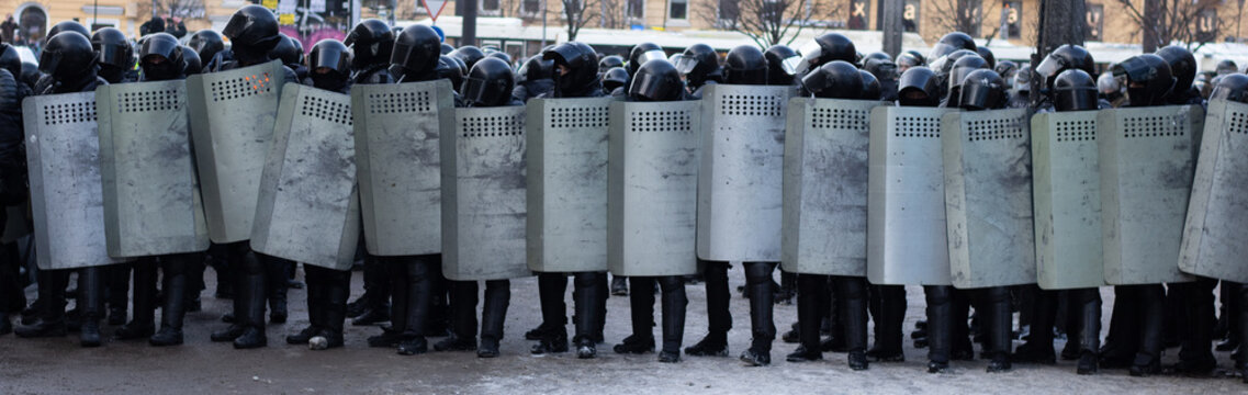 Line of police riot forces, protest in city. Uniform armor with shields