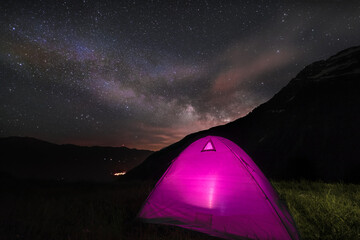 camping in the night under a sky full of stars